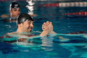 A man in the water with his arms crossed.